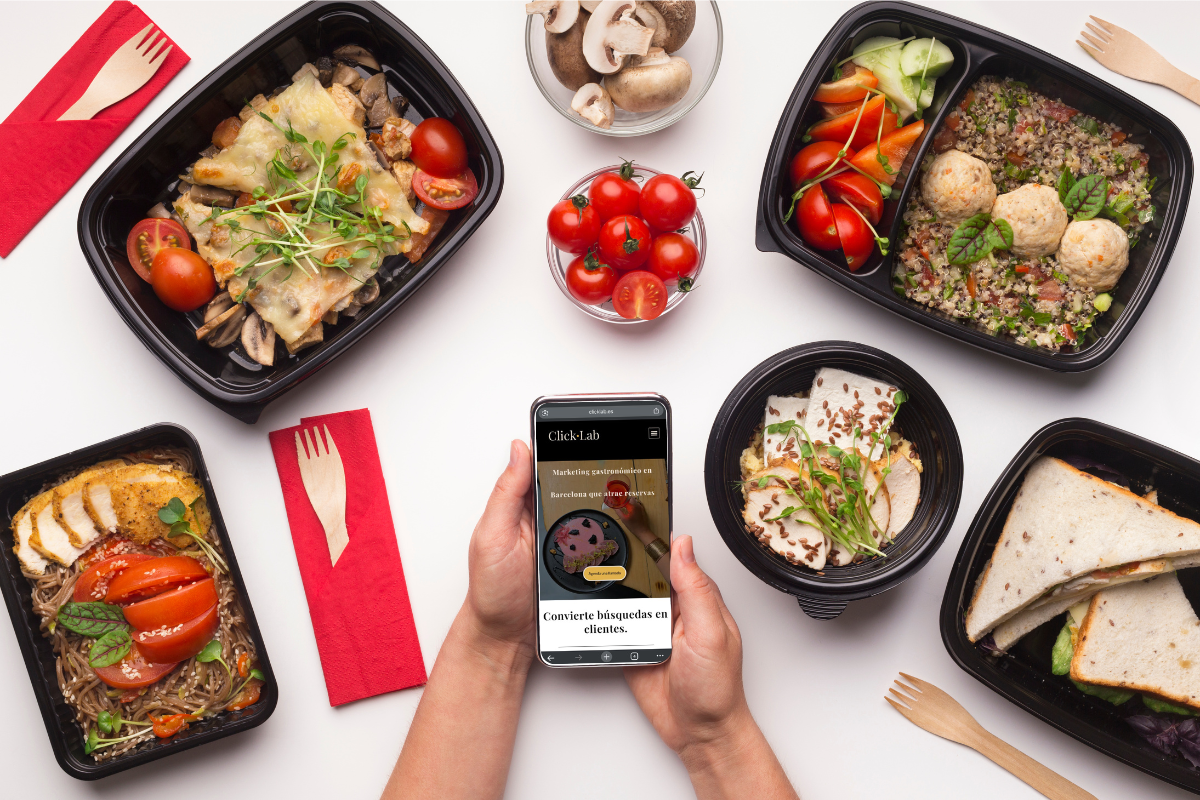 Platos saludables en envases para llevar junto a un móvil con la web de Click Lab – marketing gastronómico en Barcelona