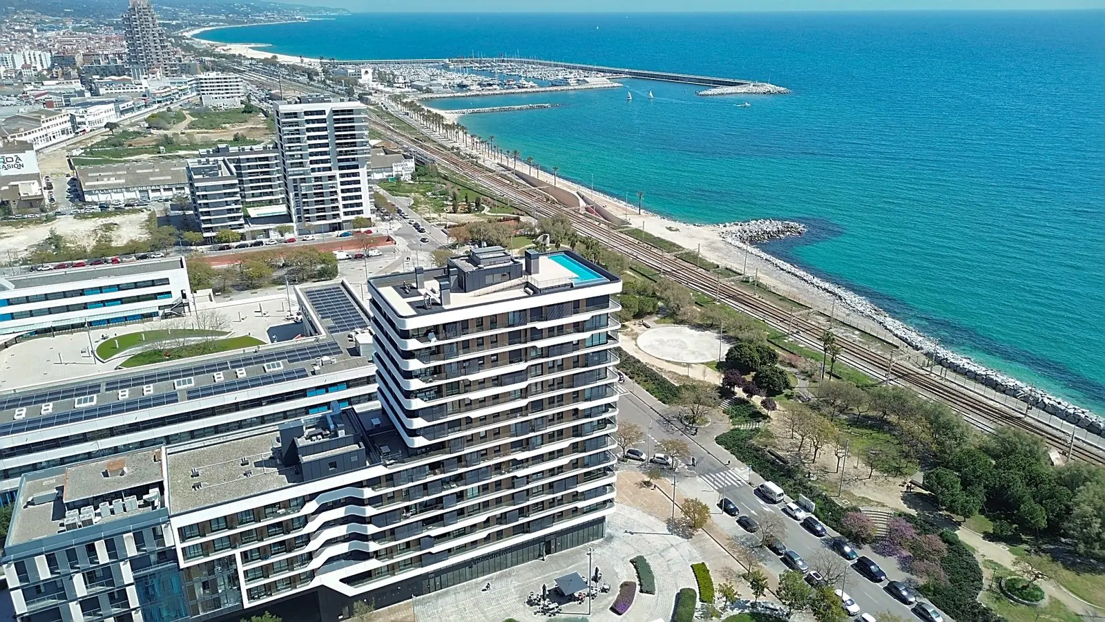 Vista aérea con drone de un edificio residencial frente al mar y el puerto deportivo