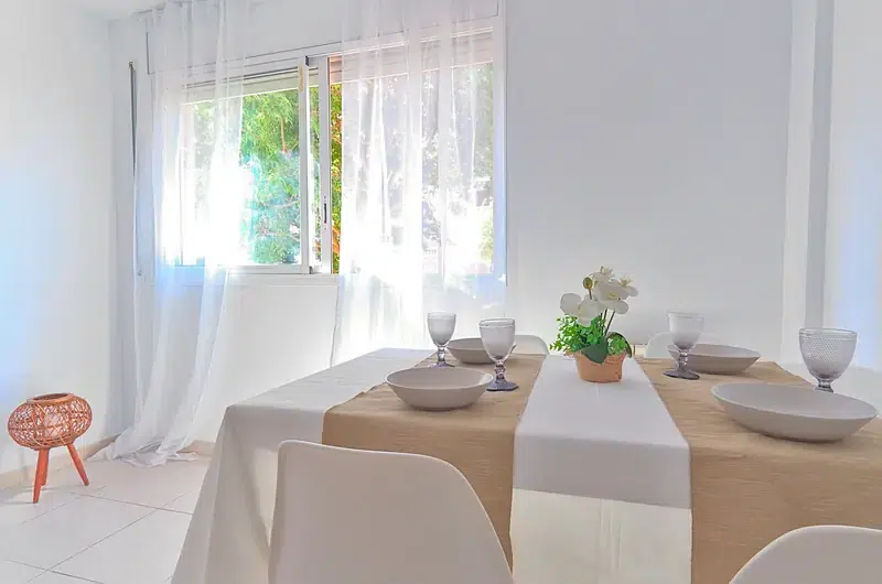 Mesa de comedor junto a una ventana con luz natural