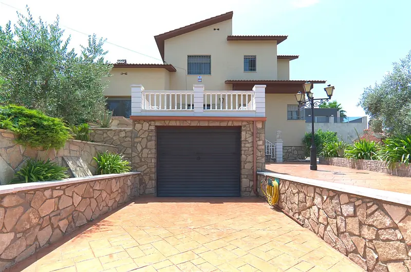 Fachada de vivienda unifamiliar con terraza y acceso al garaje