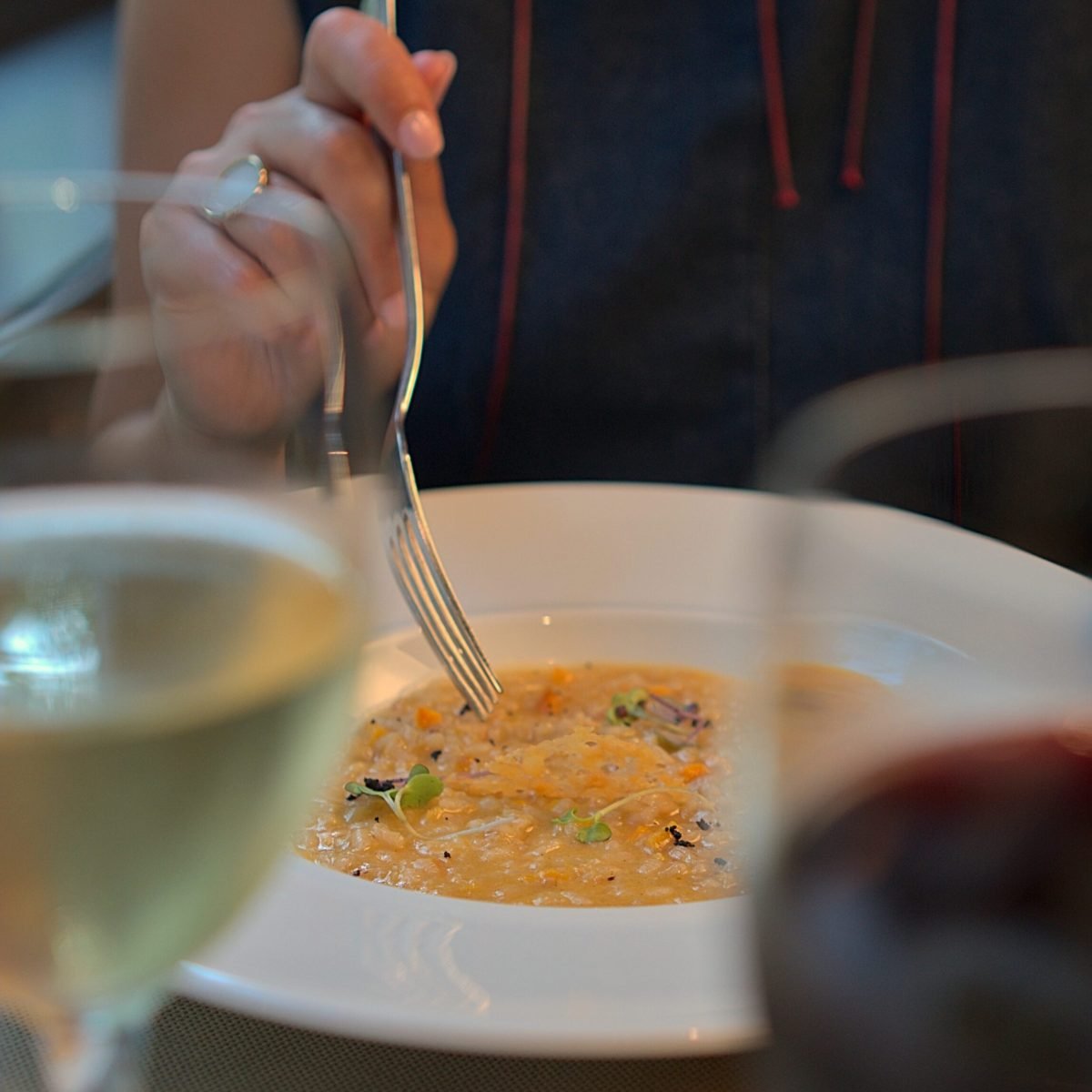 Plato de risotto servido con vino en restaurante de Barcelona, fotografía gastronómica profesional de Click Lab.