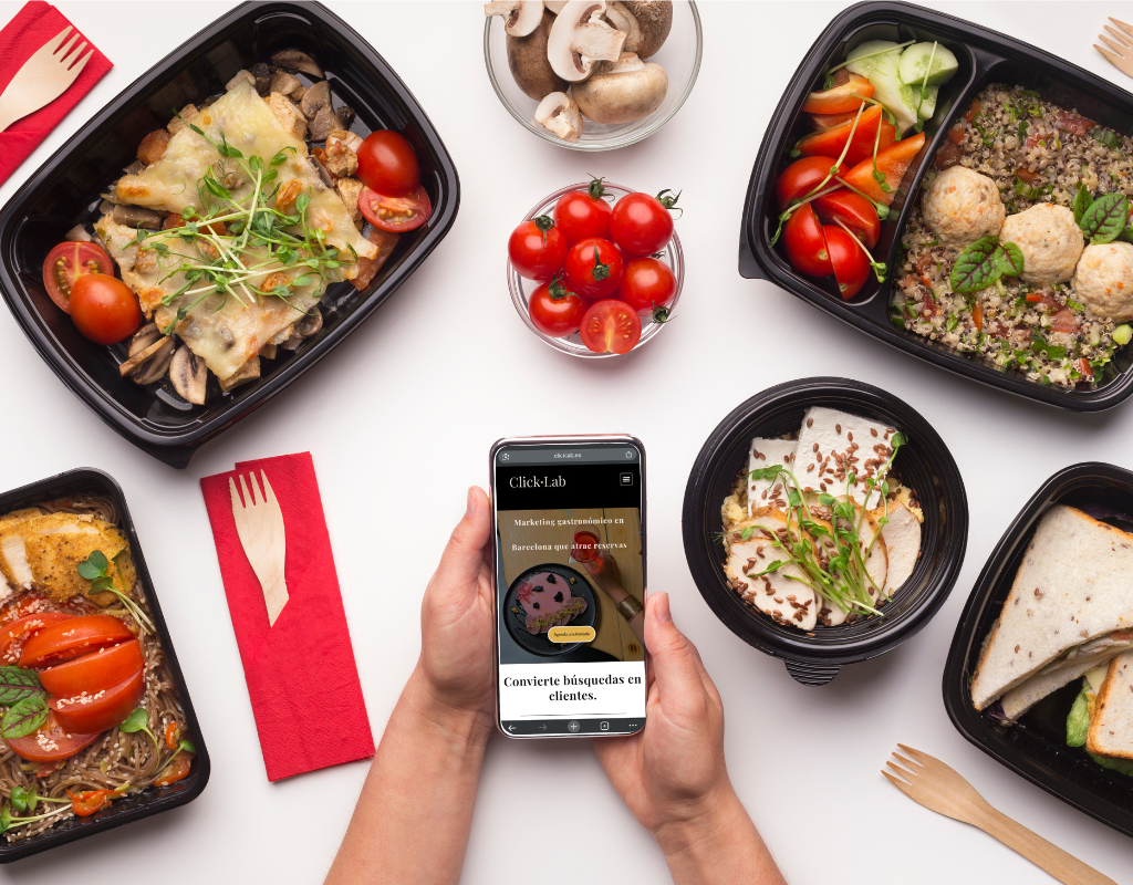 Platos saludables en envases para llevar junto a un móvil con la web de Click Lab – marketing gastronómico en Barcelona